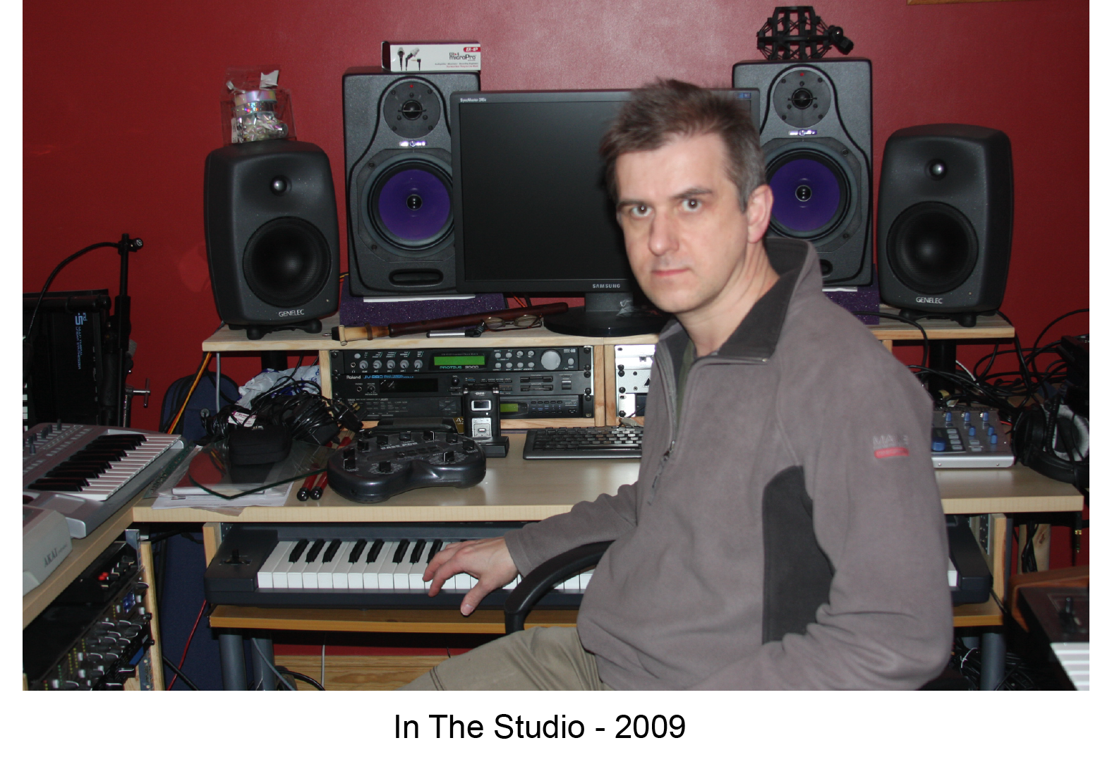 Photo of in the studio from 2009, compter screen, speakers, keyboards and other recording and music equipment